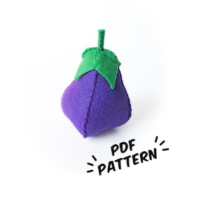 Puede incluir: Una berenjena de fieltro morado con un tallo y hojas de fieltro verde. El texto "PDF PATTERN" está escrito debajo de la berenjena.