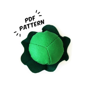 May include: A green felt cabbage with a dark green felt leaf pattern. The text "PDF PATTERN" is written in black above the cabbage.