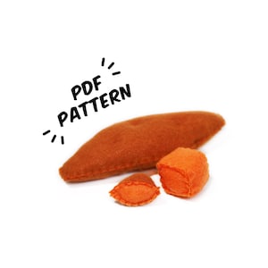 May include: An orange felt sweet potato pattern, featuring a long, pointed shape, a cube, and a small slice. The text "PDF PATTERN" is written in black above the sweet potato.