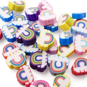May include: A collection of colourful rainbow-shaped polymer clay beads with a white cloud design. The beads are perfect for making jewellery, keychains, or other crafts.
