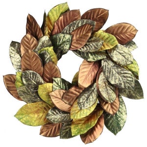 May include: A wreath made of artificial magnolia leaves in shades of green, brown, and gold. The leaves have a glittery finish.