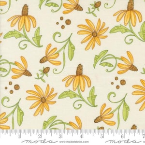 May include: A white fabric with a repeating pattern of yellow flowers with brown centers and green leaves. The fabric has a ruler with the word "moda" printed on it.