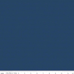 May include: A close-up of a navy blue fabric with a textured, dotted pattern. The fabric is measured with an inch ruler at the bottom of the image. The fabric is from Riley Blake Designs.