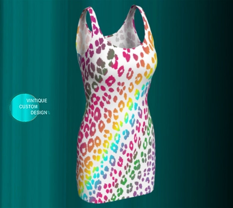 May include: A sleeveless white dress with a rainbow leopard print pattern. The dress has a scoop neck and a fitted silhouette.
