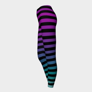 Puede incluir: Leggings largos con un patr&oacute;n de rayas horizontales que cambian de color, desde el morado en la cintura hasta el azul y el turquesa en los tobillos, intercaladas con rayas negras s&oacute;lidas en toda la prenda.