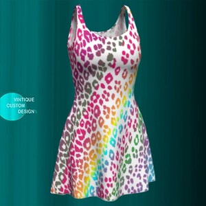 May include: A white sleeveless dress with a rainbow leopard print. The dress has a fitted bodice and a flared skirt.