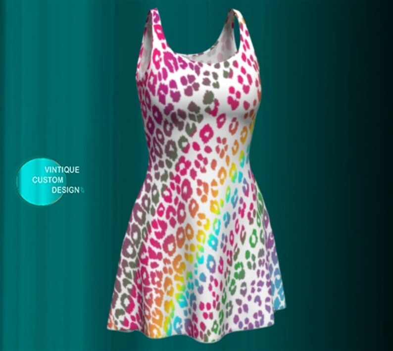 May include: A white sleeveless dress with a rainbow leopard print. The dress has a fitted bodice and a flared skirt.