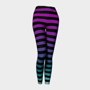 Puede incluir: Leggings largos con un patr&oacute;n de rayas horizontales que transicionan de color desde el morado en la cintura, pasando por el azul, hasta un tono turquesa en los tobillos, intercaladas con rayas horizontales negras constantes.