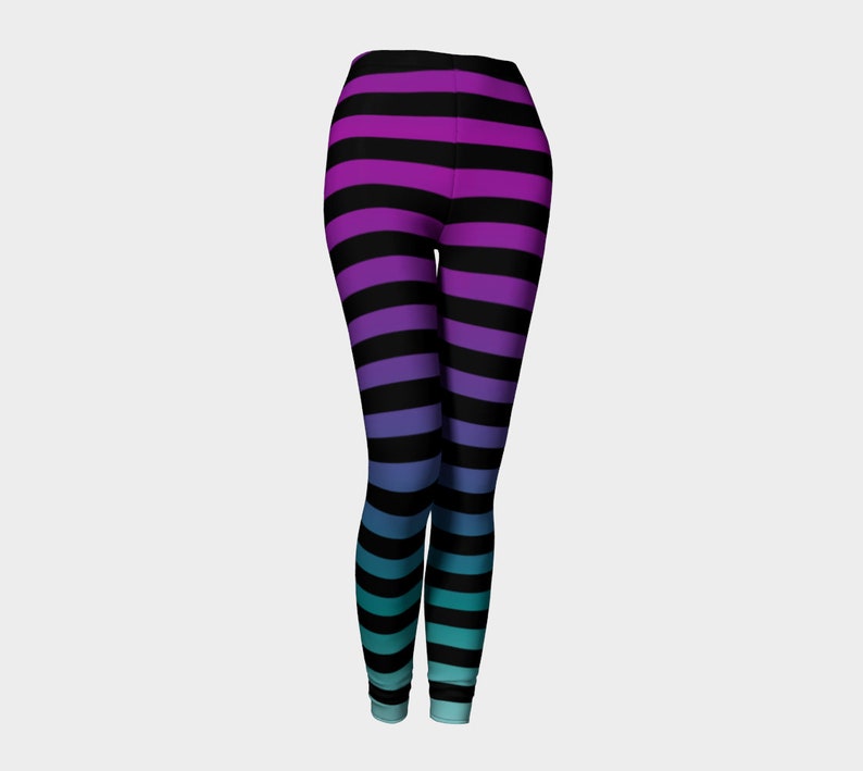 Puede incluir: Leggings largos con un patr&oacute;n de rayas horizontales que transicionan de color desde el morado en la cintura, pasando por el azul, hasta un tono turquesa en los tobillos, intercaladas con rayas horizontales negras constantes.