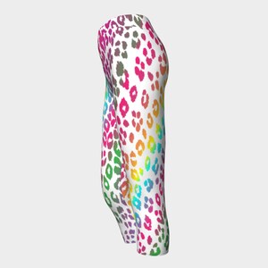 May include: Rainbow leopard print leggings with a white background. The leggings are cropped and have a tight fit.