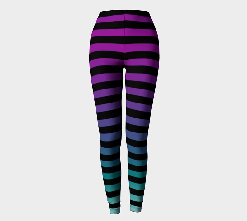 Puede incluir: Leggings de cuerpo entero con un patr&oacute;n de rayas horizontales que transicionan de color desde el morado en la cintura hasta un azul cerceta en los tobillos, con rayas negras constantes intercaladas por toda la prenda.