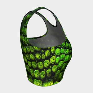 May include: Green crop top with a scaly pattern. The top has a racerback style and a cropped fit.