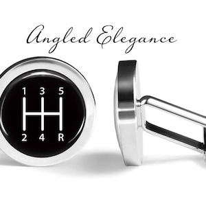 Może przedstawiać: Para srebrnych spinek do mankietów z czarnym tłem i białym wzorem zmiany biegów. Spinki do mankietów mają nadrukowane liczby 1, 2, 3, 4, 5 i R.