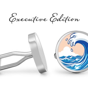 May include: Silver cufflinks featuring a circular design with a blue and white wave. The wave is breaking over a peach-coloured background with white clouds. The cufflinks are labelled "Executive Edition".