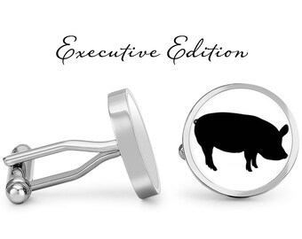 May include: A pair of silver cufflinks with a black silhouette of a pig on one cufflink. The cufflinks are labeled "Executive Edition".