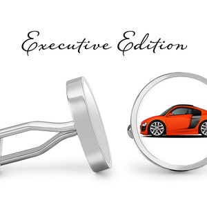 May include: Silver cufflinks with a round, white background featuring a red sports car. The cufflinks are labeled "Executive Edition".