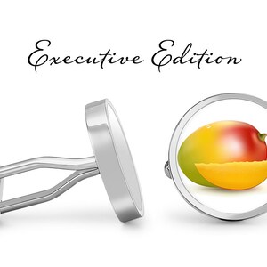 May include: Silver cufflinks with a round, white background featuring a realistic image of a mango with a slice. The text "Executive Edition" is written above the cufflinks.