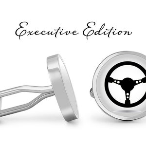 May include: A pair of silver cufflinks with a black steering wheel design. The cufflinks are labeled "Executive Edition".