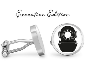 May include: A pair of silver cufflinks with a black and white image of a diving helmet. The cufflinks are labeled "Executive Edition".