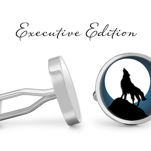 May include: A pair of silver cufflinks, one with a plain silver face and the other with a wolf howling at the moon on a blue background. The cufflinks are labeled "Executive Edition".