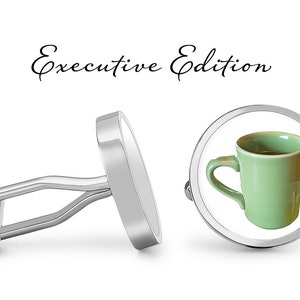 May include: Silver cufflinks with a green coffee mug design. The cufflinks are labeled "Executive Edition".