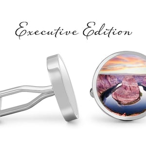 May include: Silver cufflinks with a round image of a horseshoe bend in the Colorado River at sunset. The cufflinks are labeled "Executive Edition".