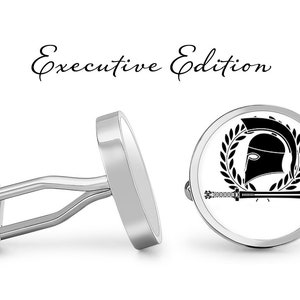 May include: A pair of silver cufflinks with a black and white design. One cufflink features a Spartan helmet with a sword and laurel wreath. The other cufflink is plain silver. The text "Executive Edition" is written above the cufflinks.