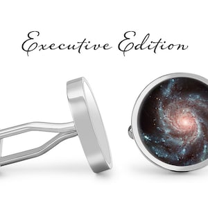May include: A pair of silver cufflinks with a round, black and blue image of a galaxy. The cufflinks are labeled "Executive Edition".