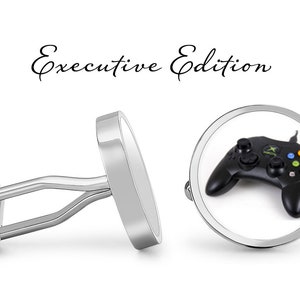 May include: A pair of silver cufflinks with a round, black and green video game controller image on one cufflink. The text "Executive Edition" is written above the cufflinks.
