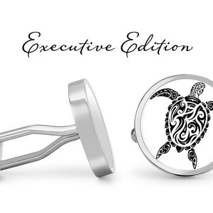 May include: Silver cufflinks with a circular design featuring a black and white stylized turtle. The cufflinks are labeled "Executive Edition".