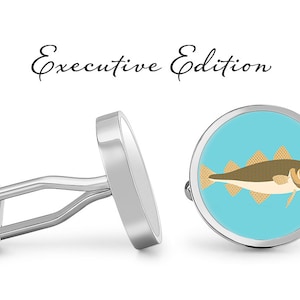 May include: Silver cufflinks with a round blue enamel design featuring a cartoon illustration of a cod fish. The cufflinks are labeled "Executive Edition".