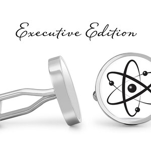 May include: Silver cufflinks with a white background and a black atom symbol. The cufflinks are labeled "Executive Edition".