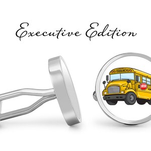 May include: A pair of silver cufflinks with a round, white background featuring a cartoon illustration of a yellow school bus with the words "School Bus" on the side. The cufflinks are labeled "Executive Edition".