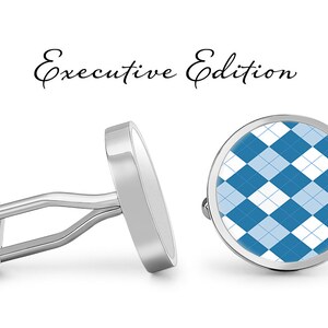 May include: A pair of silver cufflinks with a blue and white argyle pattern. The cufflinks are labeled "Executive Edition".