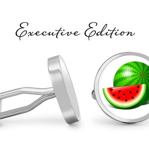 May include: Silver cufflinks with a white background and a red and green watermelon design. The cufflinks say "Executive Edition" on the top.