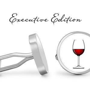 May include: Silver cufflinks with a round design. One cufflink features a glass of red wine. The other cufflink is plain. The text "Executive Edition" is written above the cufflinks.
