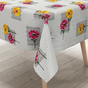 Peut inclure: Une nappe blanche avec un motif floral composé de fleurs roses et jaunes sur fond gris. La nappe a un motif géométrique subtil.