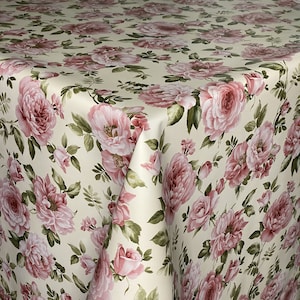 Könnte beinhalten: Cremefarbene Tischdecke mit einem sich wiederholenden Muster aus rosa Rosen und grünen Blättern. Das florale Design bedeckt die gesamte Oberfläche, mit Rosen unterschiedlicher Größe und detailliertem Laub. Der Stoff hat einen leichten Glanz, der die Farben verstärkt.