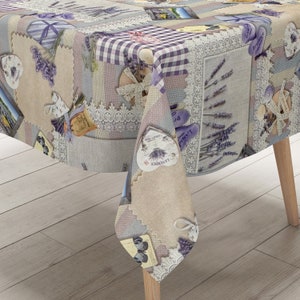 Puede incluir: Un mantel de mesa con temática de lavanda con un diseño de patchwork que presenta varias imágenes de flores de lavanda, corazones y encaje. El mantel está hecho de una tela suave y duradera y es perfecto para agregar un toque de elegancia a cualquier mesa de comedor.