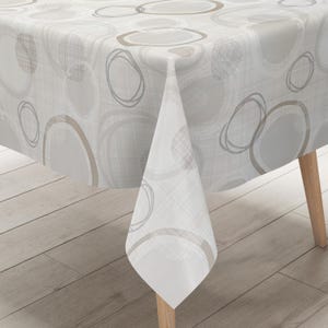 Può includere: Una tovaglia bianca caratterizzata da un motivo ripetitivo di cerchi sovrapposti in tonalità grigio chiaro, grigio scuro e beige. Il tessuto presenta una sottile trama a tratteggio incrociato e il disegno è stampato sull'intera superficie.