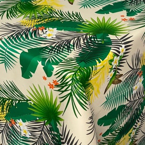 Peut inclure: Un tissu blanc avec un imprimé tropical représentant des feuilles de palmier vertes, des fleurs jaunes et de petites fleurs rouges.