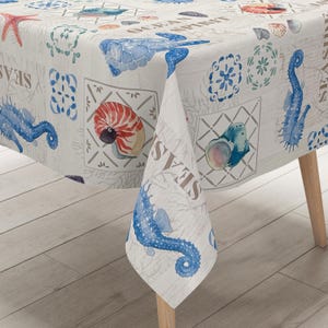Könnte beinhalten: Weiße Tischdecke mit nautischem Thema mit Seepferdchen, Muscheln und einer Schildkröte. Die Tischdecke hat ein sich wiederholendes Muster aus blauen und weißen Fliesen und den Text "Ocean Spirit" und "Seashells".