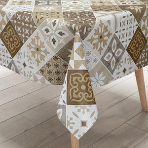 Könnte beinhalten: Eine gemusterte Tischdecke mit einem geometrischen Design in Braun-, Beige- und Weißtönen. Die Tischdecke ist über einem Holztisch drapiert und zeigt einen Patchwork aus dekorativen Fliesen. Das Design umfasst florale und geometrische Formen.