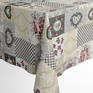 Puede incluir: Un mantel de mesa de patchwork con un diseño floral y de corazones en tonos grises, beige y rosa. El mantel está hecho de un tejido suave y tejido y presenta una variedad de patrones, incluyendo estampados florales, corazones y diseños a cuadros.