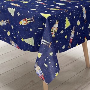 Op de afbeelding: Een blauwe tafelkleed met een herhalend patroon van notenkrakers, kerstboom, sterren en sneeuwvlokken.