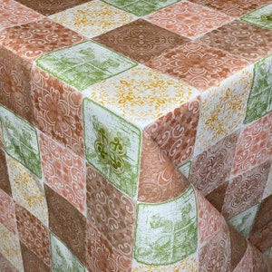 Puede incluir: Un mantel con un diseño de patchwork en varios tonos de marrón, verde y blanco. El patrón incluye intrincados motivos florales y geométricos.