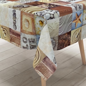 Op de afbeelding: Een rechthoekig tafelkleed met een patchwork-ontwerp met verschillende texturen en patronen, waaronder schelpen, kiezelsteentjes, hout en het woord "LOVE". Het tafelkleed is beige, bruin en blauw.