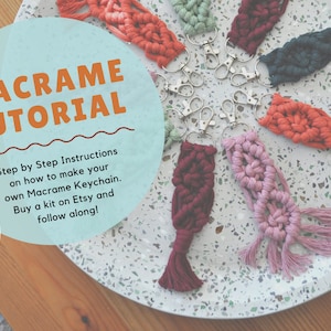 May include: A close-up of a variety of colorful macrame keychains on a white speckled surface. The keychains are made with different colored cords and have a tassel at the end. The image includes the text "MACRAME TUTORIAL" and "Step by Step Instructions on how to make your own Macrame Keychain. Buy a kit on Etsy and follow along!" and the text "NEW".