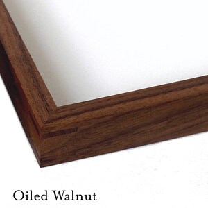 May include: Three wooden picture frames in different finishes: black walnut, oiled walnut, and natural walnut. Each frame is made of solid wood and has a simple, elegant design.