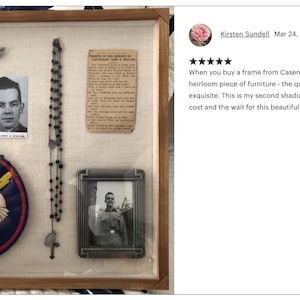 May include: A shadow box with a wooden frame and a white background. The box contains a variety of items, including a photo of a man, a patch with a number 9, a small silver airplane, a rosary, a small framed photo of a man, and a patch with a red, white, and blue eagle design. The text in the image reads "When you buy a frame from Casenumber11, you are getting an heirloom piece of furniture - the quality of the craftsmanship is exquisite. This is my second shadow box purchase. Well worth the cost and the wait for this beautiful creation."